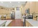Spacious kitchen with light wood cabinets, white countertops, and stainless steel appliances and plenty of counter space at 10726 Miracle Ln, New Port Richey, FL 34654