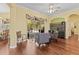 Bright living room featuring wood floors, a ceiling fan, an arched doorway, and sliding glass doors to a screened in patio at 10726 Miracle Ln, New Port Richey, FL 34654