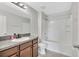 Well-lit bathroom with vanity, granite countertop, and a tub/shower with a shower curtain at 10936 Rainbow Pyrite Dr, Wimauma, FL 33598