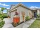 Beautiful home exterior showing landscaped walkway with decorative wooden trellises, leading to the front door at 10936 Rainbow Pyrite Dr, Wimauma, FL 33598