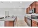 Kitchen featuring granite countertops, wood cabinets, an island with sink, and appliances for modern convenience at 10936 Rainbow Pyrite Dr, Wimauma, FL 33598