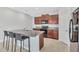 Modern kitchen with granite countertops, dark wood cabinets, and a central island with seating at 10936 Rainbow Pyrite Dr, Wimauma, FL 33598