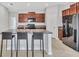 An open kitchen boasts granite countertops, dark wood cabinets, and stainless steel appliances at 10936 Rainbow Pyrite Dr, Wimauma, FL 33598