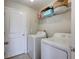 Functional laundry room features a full-size washer and dryer, and storage shelf at 10936 Rainbow Pyrite Dr, Wimauma, FL 33598