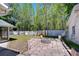 Outdoor patio area with brick flooring, a fire pit, tall trees and white fenced yard perfect for entertaining at 1120 Country Ln, Lutz, FL 33558