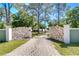 Impressive gated driveway entrance with stone accents and a well-maintained lawn at 1120 Country Ln, Lutz, FL 33558