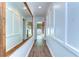 Hallway with wood floors, white walls, decorative molding and a view into the sunroom at 1120 Country Ln, Lutz, FL 33558
