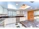 Well-lit kitchen featuring stainless steel appliances, ample counter space, and green and white tiling at 1120 Country Ln, Lutz, FL 33558