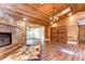 Spacious living room features a stone fireplace, wood floors, wood ceilings and built in bookshelves at 1120 Country Ln, Lutz, FL 33558
