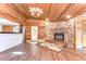 Spacious living room features a stone fireplace, wood floors, wood ceilings, and a kitchen view at 1120 Country Ln, Lutz, FL 33558