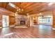 Spacious living room features a stone fireplace, wood floors, wood ceilings, and a stylish chandelier at 1120 Country Ln, Lutz, FL 33558