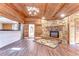 Spacious living room features a stone fireplace, wood floors, wood ceilings, and a kitchen view at 1120 Country Ln, Lutz, FL 33558