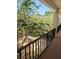 View from balcony overlooking a lush courtyard with mature trees and a painted railing at 120 S Church Ave # 207, Tampa, FL 33609