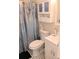 Bathroom featuring white vanity, toilet, and a cabinet with blue accents, complemented by a decorative shower curtain at 120 S Church Ave # 207, Tampa, FL 33609