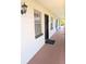 White apartment building with a black door and a light fixture at 120 S Church Ave # 207, Tampa, FL 33609