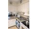 Kitchen with white cabinets, granite countertops, stainless steel sink and white appliances at 120 S Church Ave # 207, Tampa, FL 33609
