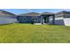 A spacious backyard with a covered patio area, a well-maintained lawn, and white fencing at 12123 Ledbury Commons Dr, Gibsonton, FL 33534