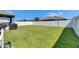 Large, grassy backyard enclosed by a white fence, offering privacy and ample space at 12123 Ledbury Commons Dr, Gibsonton, FL 33534