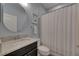 Well lit full bathroom with light blue walls, granite sink, toilet and shower/tub with white shower curtain at 12123 Ledbury Commons Dr, Gibsonton, FL 33534
