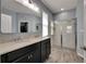 Bathroom featuring a double sink vanity, marble floors, and a glass shower, offering a luxurious space at 12123 Ledbury Commons Dr, Gibsonton, FL 33534