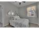 Light and airy bedroom with wood-look flooring, ceiling fan, window and modern light fixture at 12123 Ledbury Commons Dr, Gibsonton, FL 33534