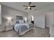 Cozy bedroom featuring a ceiling fan, wood-look floors, neutral paint, and easy access to the bathroom at 12123 Ledbury Commons Dr, Gibsonton, FL 33534