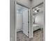 A view into an open door to a bedroom with a ceiling fan and wood look flooring and a bathroom with a shower and white curtain at 12123 Ledbury Commons Dr, Gibsonton, FL 33534