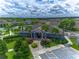 Aerial view of the clubhouse surrounded by lush landscaping, palm trees and an American flag at 12123 Ledbury Commons Dr, Gibsonton, FL 33534