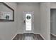 Well-lit entryway with a decorative front door, wood-look floors, and a mirror at 12123 Ledbury Commons Dr, Gibsonton, FL 33534