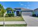 Charming single-story home featuring a well-manicured lawn and a two-car garage at 12123 Ledbury Commons Dr, Gibsonton, FL 33534