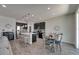 Open-concept kitchen and dining area with stainless steel appliances, island, and wood flooring at 12123 Ledbury Commons Dr, Gibsonton, FL 33534