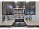 Kitchen featuring stainless steel microwave, backsplash, and granite countertops at 12123 Ledbury Commons Dr, Gibsonton, FL 33534
