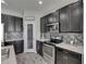 Close-up of the kitchen featuring stainless steel oven, gray cabinets, and mosaic tile backsplash at 12123 Ledbury Commons Dr, Gibsonton, FL 33534