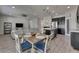Inviting living area with a dining table set, open to a modern kitchen with dark cabinets and stainless steel appliances at 12123 Ledbury Commons Dr, Gibsonton, FL 33534