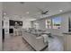 Open-concept living room with a large gray sectional sofa, tile floors, and a view of the modern kitchen at 12123 Ledbury Commons Dr, Gibsonton, FL 33534