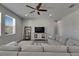 Cozy living room with a large sectional sofa, ceiling fan, and stylish shelving unit, perfect for relaxation at 12123 Ledbury Commons Dr, Gibsonton, FL 33534
