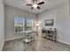 Bright home office with wood look floors, two windows with blinds, modern desk, and a bookshelf with decor at 12123 Ledbury Commons Dr, Gibsonton, FL 33534
