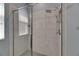 Modern shower with tiled walls, showerhead, handheld showerhead and glass doors at 12123 Ledbury Commons Dr, Gibsonton, FL 33534