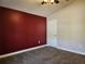 Carpeted bedroom featuring neutral walls, a dark red accent wall, and a ceiling fan at 13400 Old Florida Cir, Hudson, FL 34669
