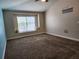 This carpeted bedroom features a sunny window nook with comfortable pillows at 13400 Old Florida Cir, Hudson, FL 34669