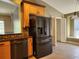 View of the kitchen with stainless steel dishwasher, refrigerator and tile flooring at 13400 Old Florida Cir, Hudson, FL 34669