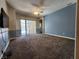 Large living room with neutral carpet, access to lanai, and blue and white two-tone walls at 13400 Old Florida Cir, Hudson, FL 34669