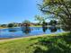 Scenic pond view with green grass and reflections of houses in the distance offers a serene and picturesque setting at 13400 Old Florida Cir, Hudson, FL 34669