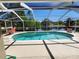 Screened-in pool area with lounge chairs and scenic views of a tranquil lake and trees at 13400 Old Florida Cir, Hudson, FL 34669