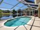 A private, screened-in pool with scenic lake views and outdoor seating at 13400 Old Florida Cir, Hudson, FL 34669