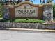 Community sign for Pine Ridge at Sugar Creek, a deed restricted community, surrounded by lush landscaping at 13400 Old Florida Cir, Hudson, FL 34669