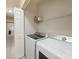Functional laundry room with modern washer and dryer units and storage shelving at 14936 Salamander Pl, Tampa, FL 33625