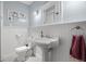 Charming bathroom featuring a pedestal sink, black and white tile floor, and beadboard paneling at 1603 S Arrawana Ave, Tampa, FL 33629