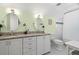 Bright bathroom features dual sinks with granite countertops and white cabinets and trim at 1603 S Arrawana Ave, Tampa, FL 33629