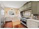 Well-equipped kitchen showcasing stainless steel appliances, custom cabinets, a farmhouse sink, and hardwood flooring at 1603 S Arrawana Ave, Tampa, FL 33629